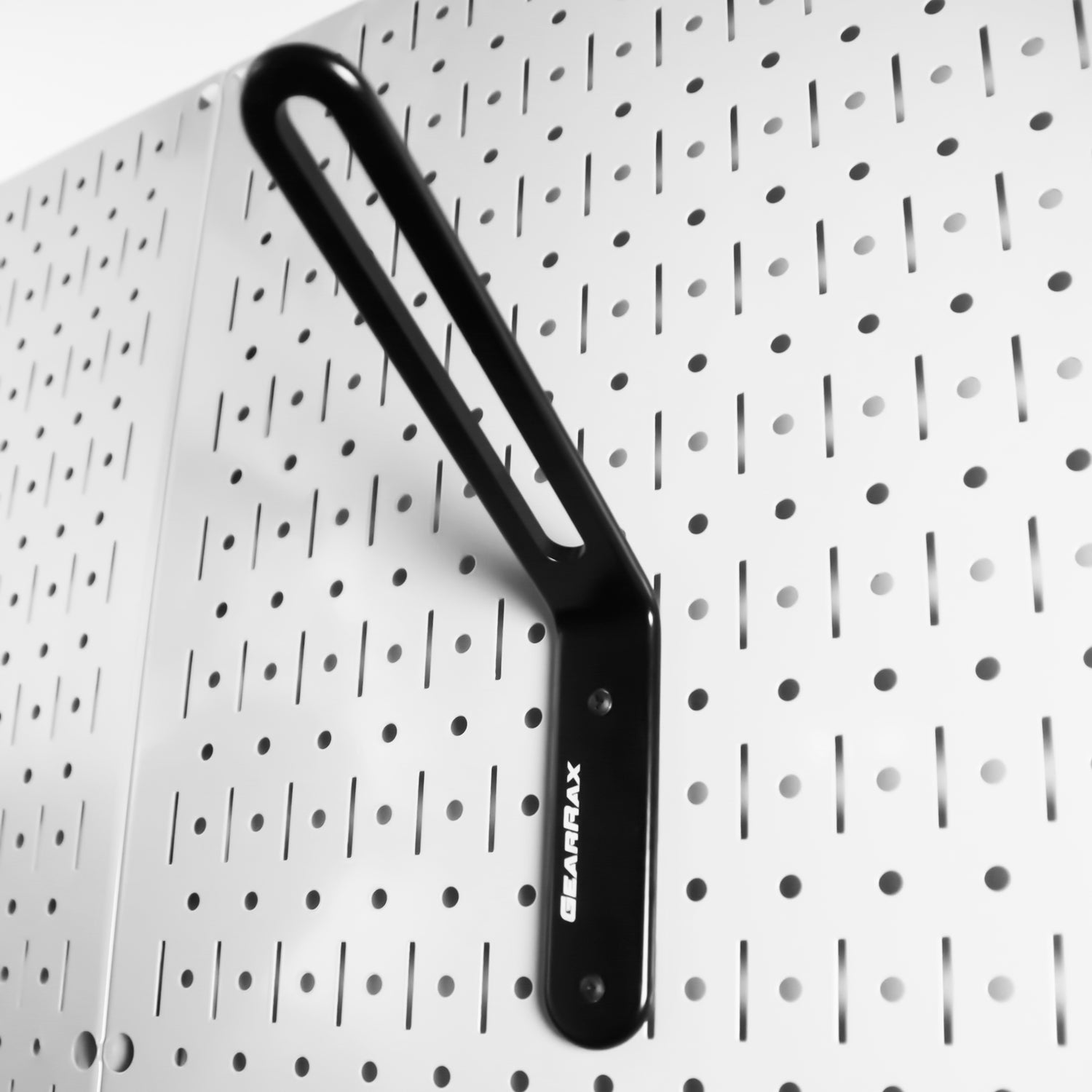 Black gearhook on a pegboard with a patterned background